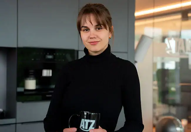 ATZ Group copywriter holding an ATZ mug